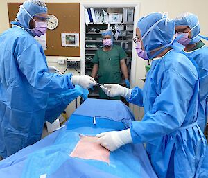 Four lay surgical assistants practice surgical procedures in theatre
