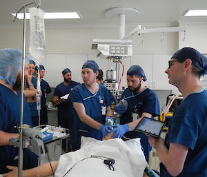 A doctor and group of lay surgical assistants in training medial room