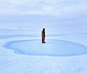 An expeditioner standing on the ice looking out into the distance