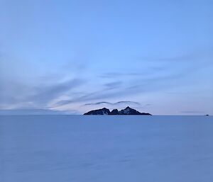 Portrait of a mountain in the distance with an interesting cloud over it