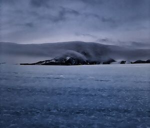 Portrait of a mountain in the distance with a cloud enveloping it