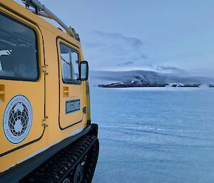 A Hagglunds and a mountain in the distance on the ice