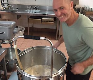 Man standing over a large brewing pot in the station kitchen