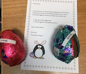A letter from the 'easter penguin' on a table with two chocolate easter eggs