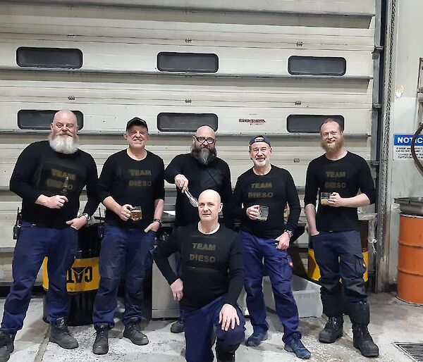 A group of expeditioners standing in the workshop