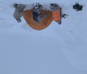 Three expeditioners freezing next to a tent