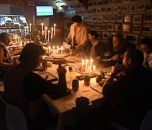 Everybody seated at the table, eating dinner, wearing medieval themed costumes.