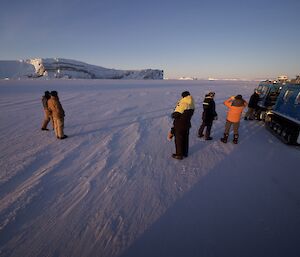 A group of expeditioners on the look out for the penguin rookery amongst icebergs