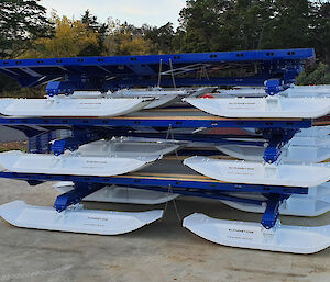 Three steel sleds with skis, stacked on top of each other.