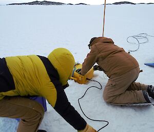 Two expeditioners deploying the mass balance thermistor measurement