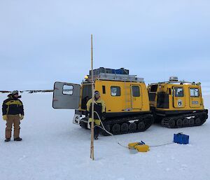 Two expeditioners setting up equipment on the sea ice