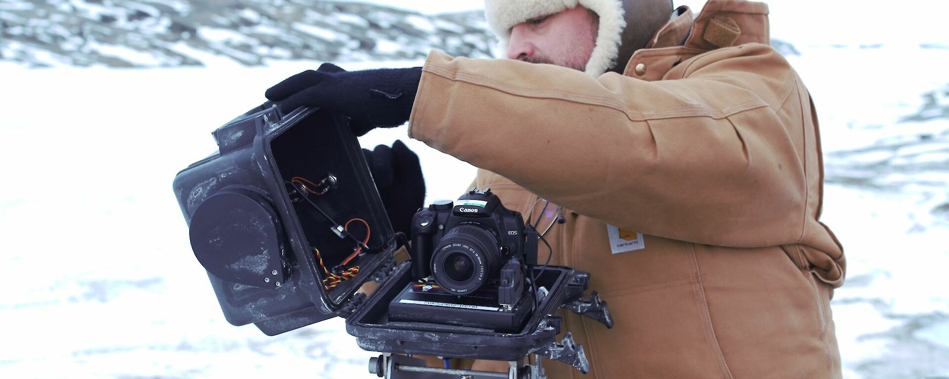 An expeditioner repairing an automated camera