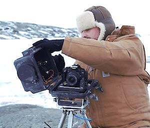 An expeditioner repairing an automated camera