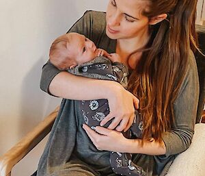 A mum holds a baby in her arms