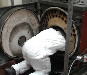 A plumber cleaning a boiler