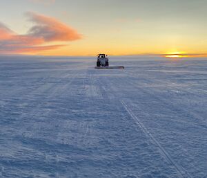 A tractor pulling a drag beam along the road to the ice runway