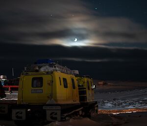 The yellow Hagglund lit by moonlight while parked up at Casey