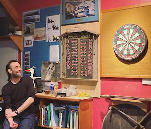 Expeditioneer sitting in front of the scoreboard and dartboard