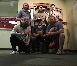 A team photo featuring 6 players holding the winning trophy