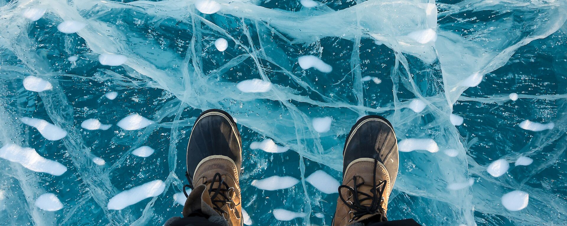 Close-up of an expeditioners feet, standing on glassy ice