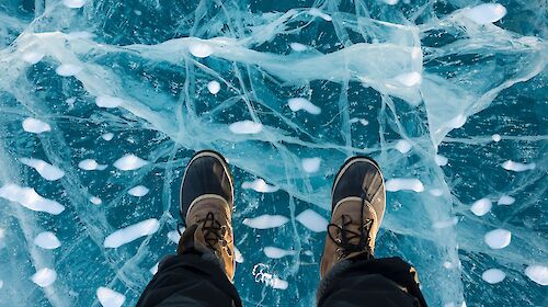 Close-up of an expeditioners feet, standing on glassy ice