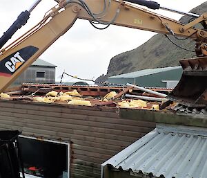 excavator bucket holds roof in place