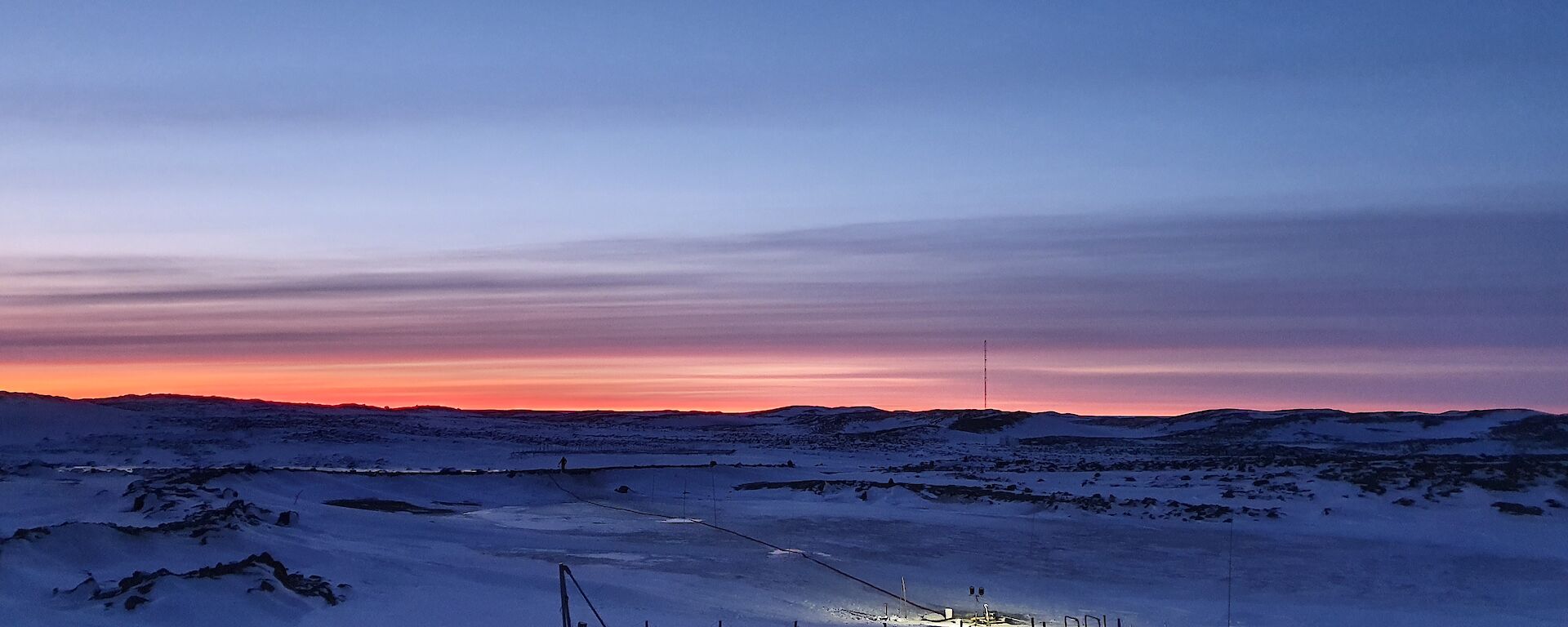 view from the station over the frozen water resevoir with a sunrise coming over the horizon