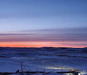 view from the station over the frozen water resevoir with a sunrise coming over the horizon