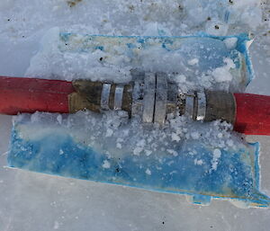 Two hoses coming together at a joint, which has completely frozed where water has escaped