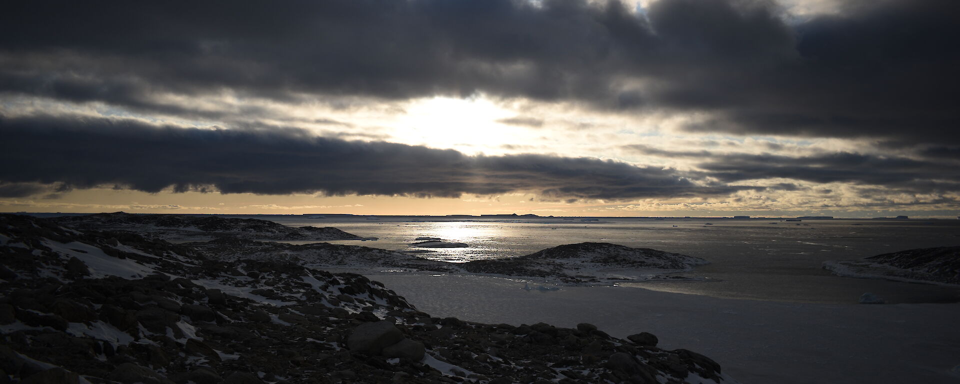 A constrasting sky with blue showing through and dark but light rimmed clouds looking towards the mouth of Newcomb Bay