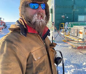 Sam Jacobs the Wilkins mechanic with icy beard.  Portrait style looking to camera with sunglasses on.