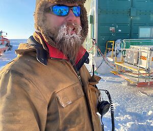 Sam Jacobs the Wilkins mechanic with icy beard.  Portrait style looking to camera with sunglasses on.