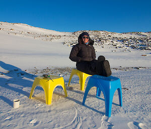 Expeditioner sitting on plastic chairs on the ice