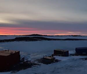 Shot of Mawson station at dusk with sunset in background