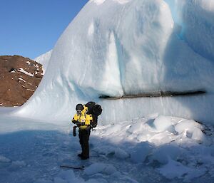 An expeditioner stands in front of an unusual ice formation