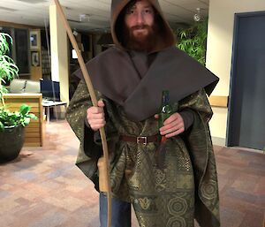 An expeditioner stands in a Robin Hood costume with a large bow