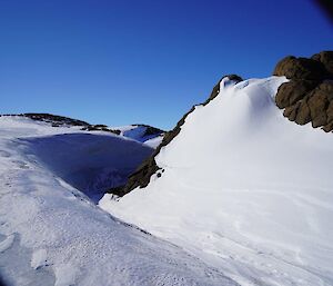 An icy wind-scoop around a rocky outcrop on the Mitchell Peninsula near Casey