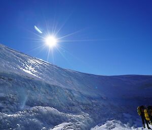 Two expeditioners with survival packs walking around a wind scoop near Casey on a nice summers day