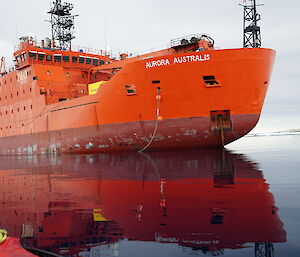 The bright orange RV Aurora Australis on the sea reflected beautifully in the calm water