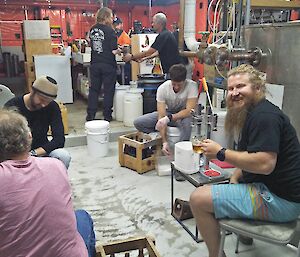 The expeditioners working and chatting inside the station makeshift brewery