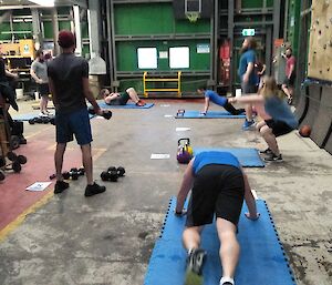 A group of expeditioners undertaking various fitness activities in the gym