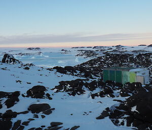 A hut in the snow with rocky outcrops