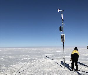 The Automatic Weather Station equipment with an expeditioner making observations
