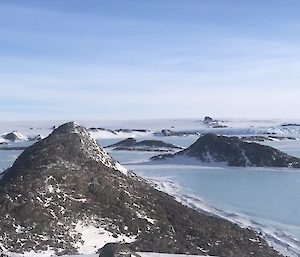 Pointed rocky outcrop in foreground with more poking out of the snow in the distance