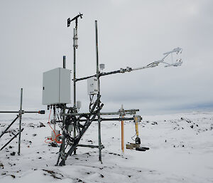 A science instrument with poles and wires in the snow