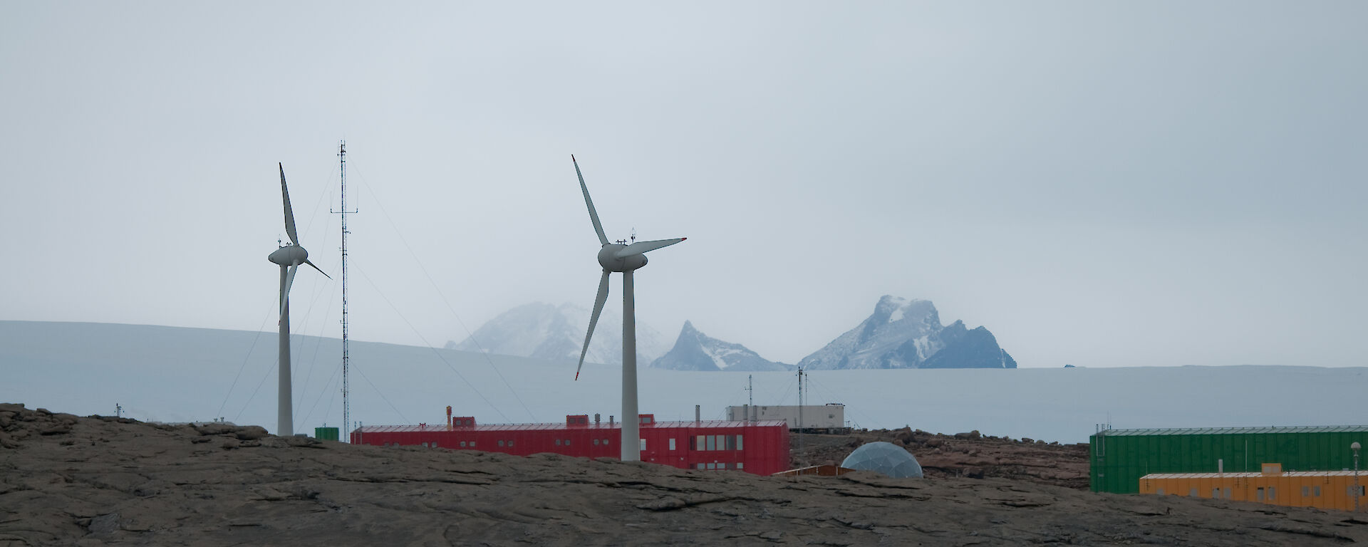 Wind turbine towers with mountain range in distance behind