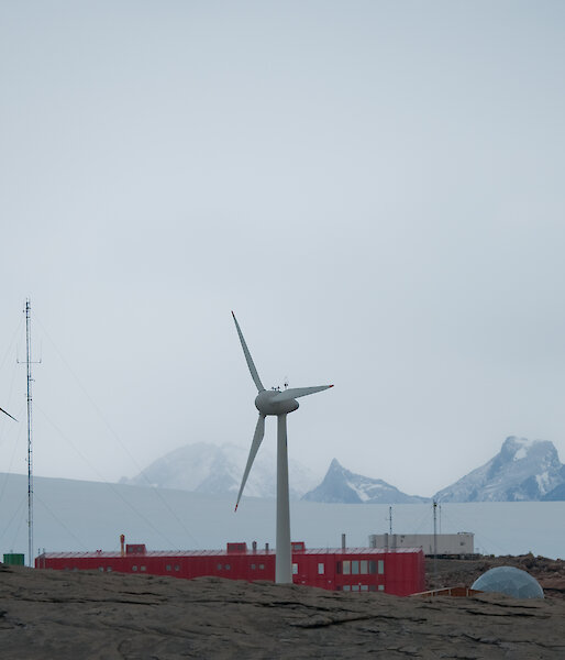 Wind turbine towers with mountain range in distance behind