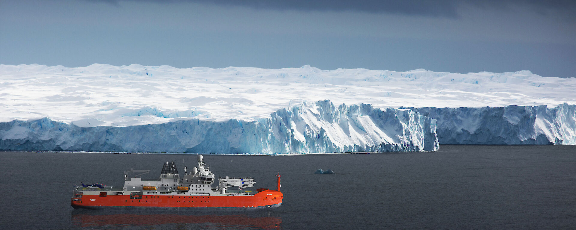 A render of the RSV Nuyina in front of an ice cliff. Image: Damen
