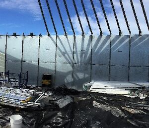 Inside a large container with no roof, full of debris