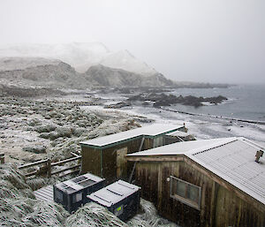 The Green Gorge field hut and the bay covered in snow. Snow capped hills are in the background